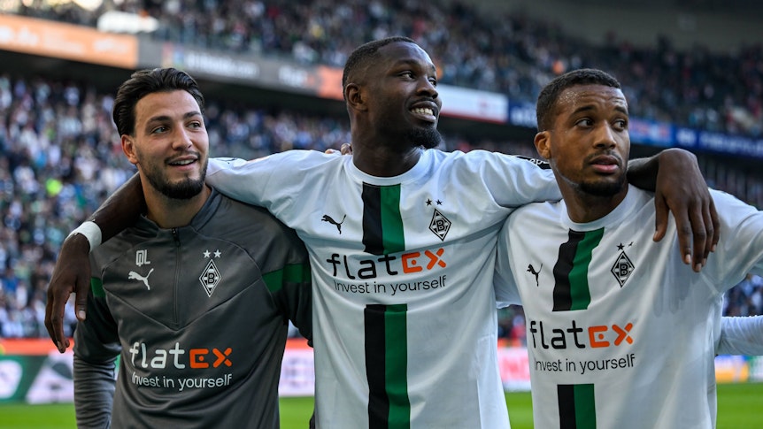 Arm in Arm! Ramy Bensebaini (l.), Marcus Thuram (m.) und Alassane Plea (r.) feiern den Sieg von Borussia Mönchengladbach gegen den 1. FC Köln am 9. Oktober 2022.