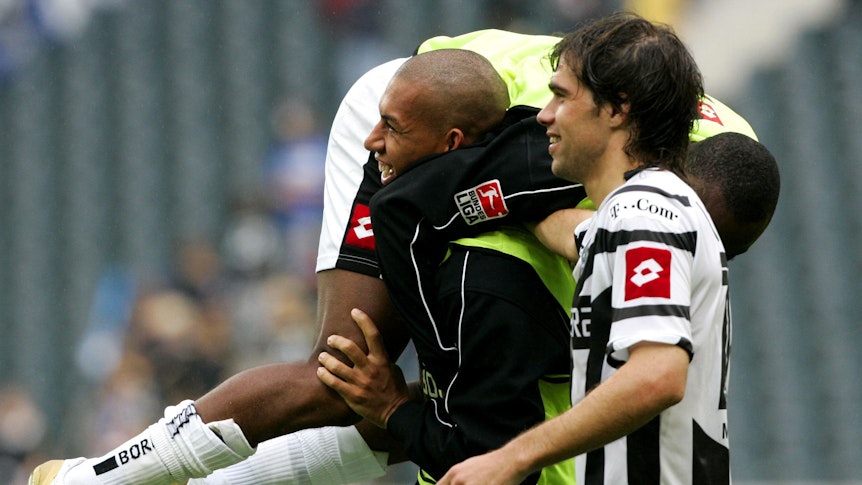 Federico Insúa (r.) freut sich nach einem Sieg von Borussia Mönchengladbach über Arminia Bielefeld mit Torschütze Kahe (l.), der Nando Rafael schultert.