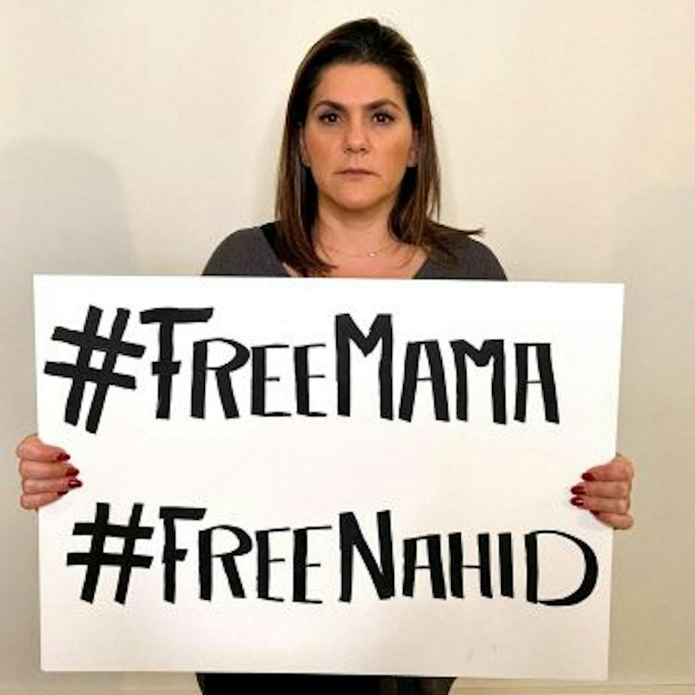 Mariam Claren hält ein Schild mit der Aufschrift „#FreeMama, #FreeNahid“ in die Kamera