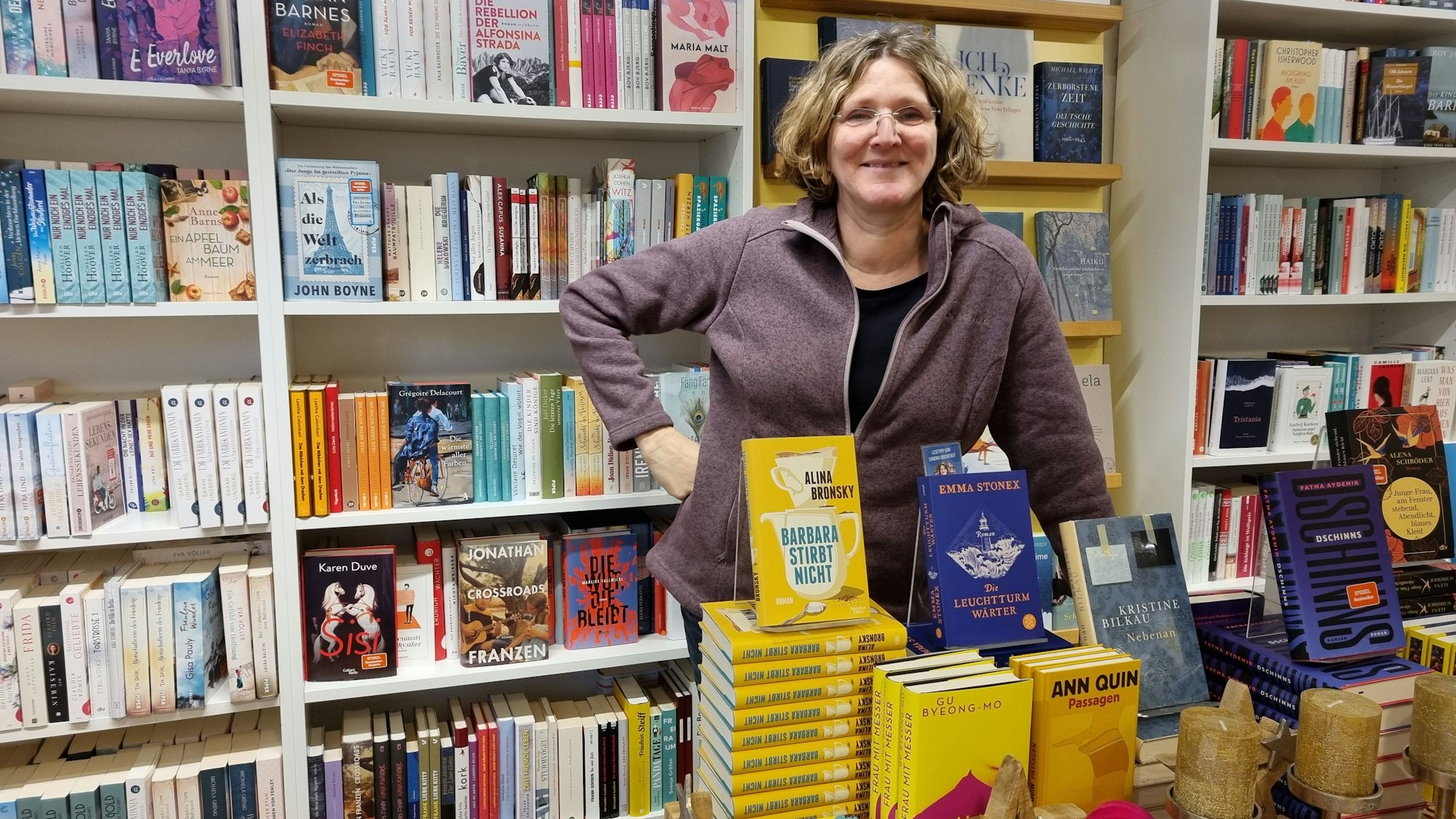 Ute Hentschel steht hinter Büchertischen in ihrer Buchhandlung in Burscheid