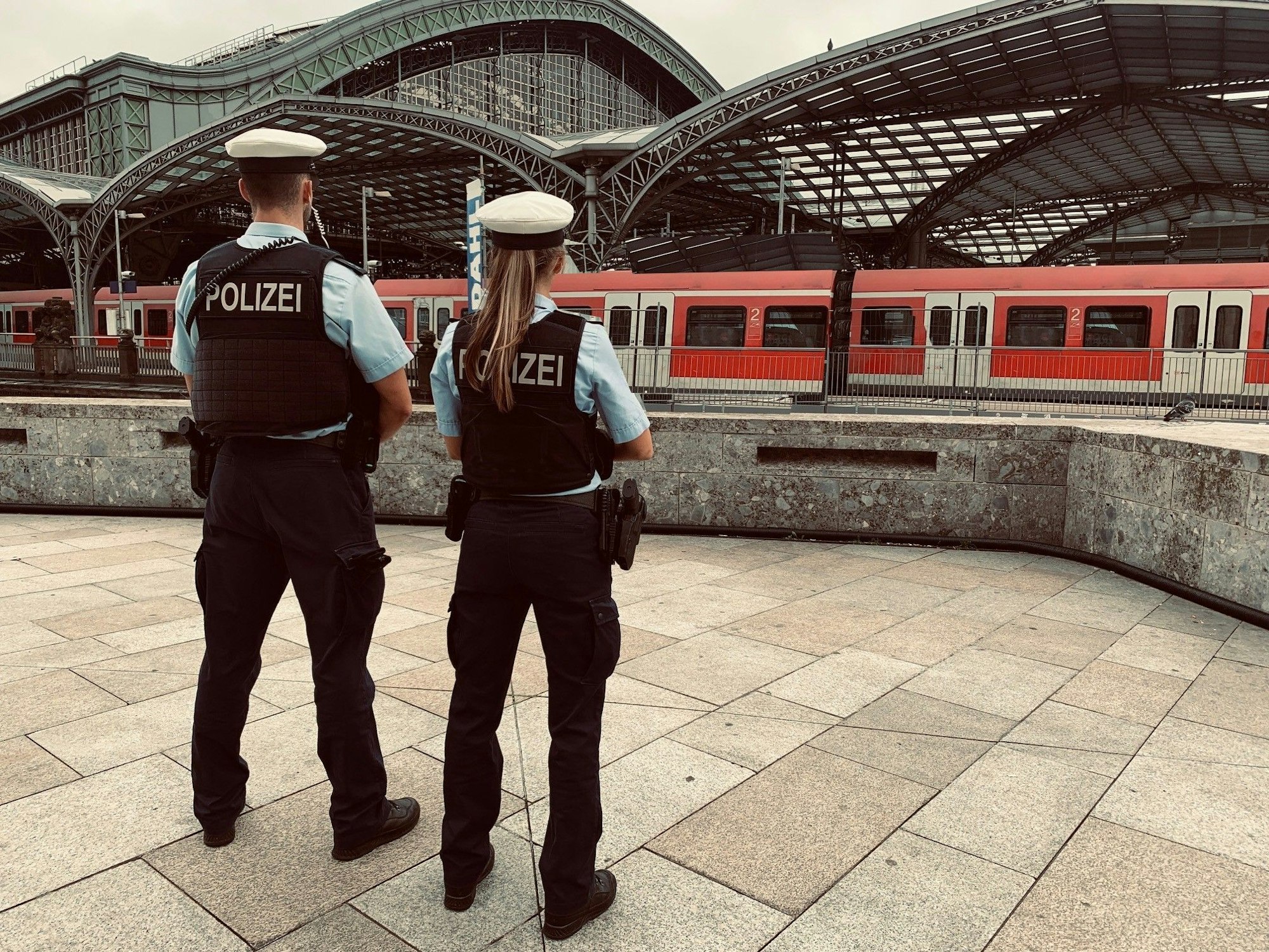 Zwei Bundespolizisten stehen vor dem Kölner Hauptbahnhof.