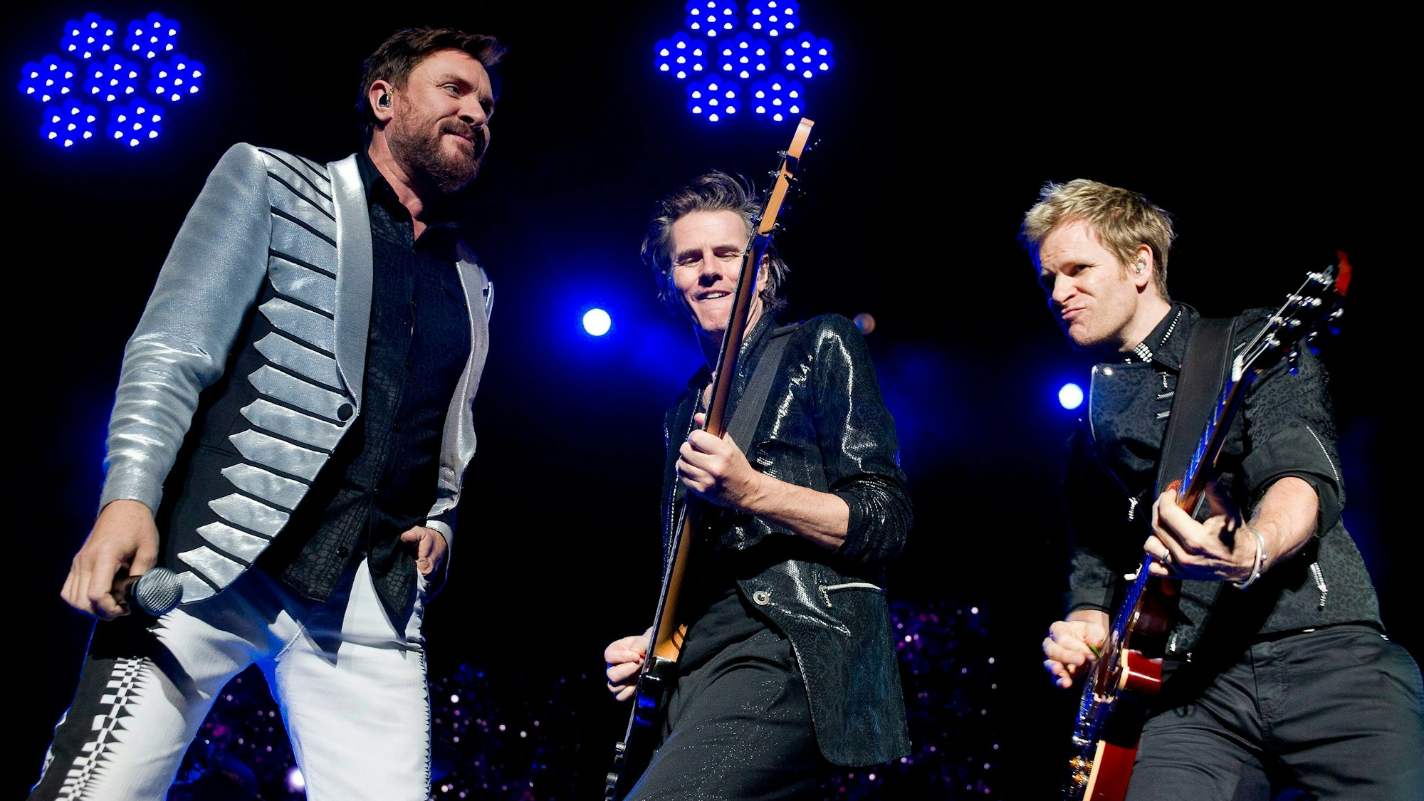 Duran Duran bei ihrem Auftritt. Links Frontmann Simon Le Bon und seine Bandkollegen an der Gitarre.