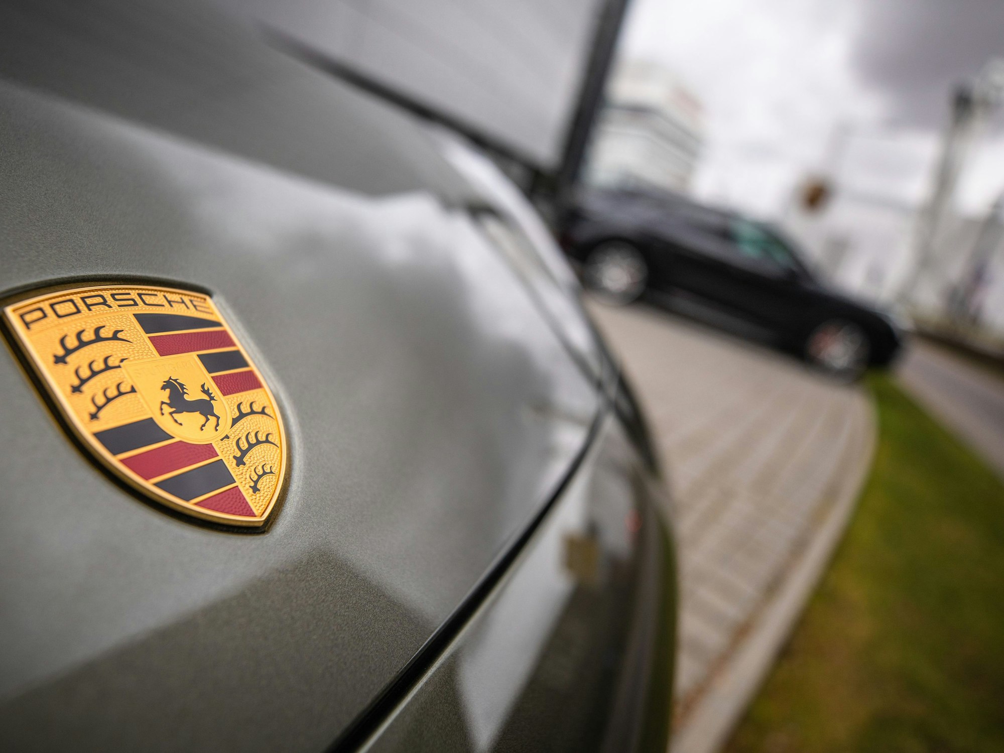 Das Porsche-Logo ist am Firmensitz in Stuttgart-Zuffenhausen auf einem Auto zu sehen.
