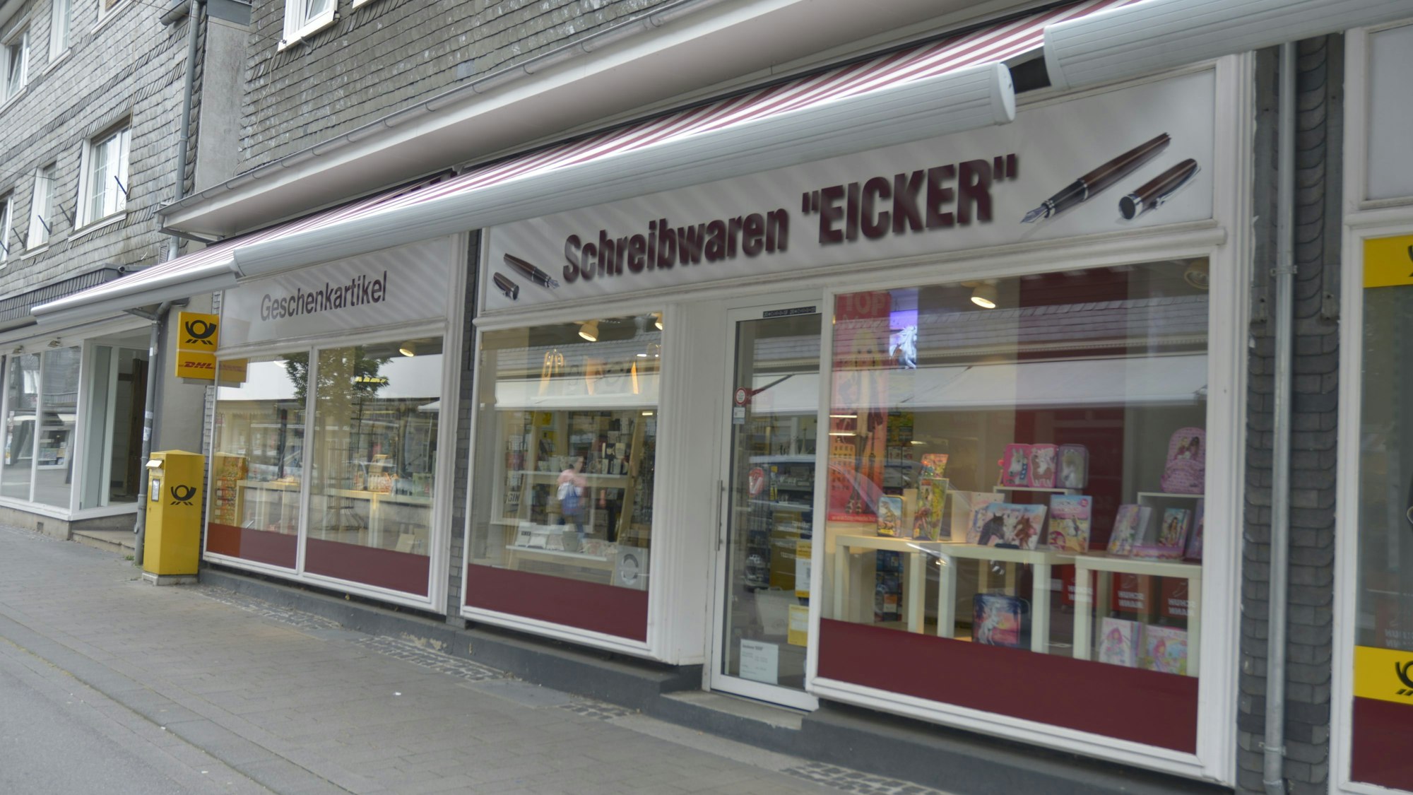 Vor dem Schreibwarengeschäft Eicker in Wipperfürth steht ein Briefkasten der Deutschen Post.