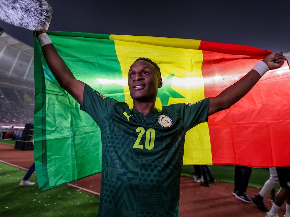 Bouna Sarr hält eine Senegal-Flagge.
