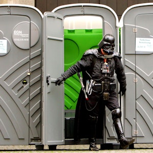 „Darth Vader“ verlässt auf dem Alter Markt in Köln eine mobile Toilette.