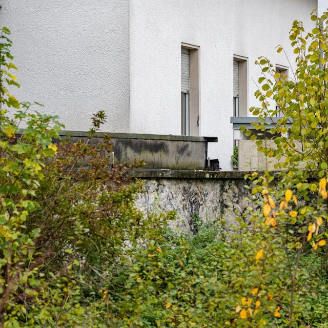 Blick auf ein weißes Haus hinter Buschwerk, in dem ein acht Jahre altes Mädchen fast ihr ganzes Leben lang festgehalten wurde.