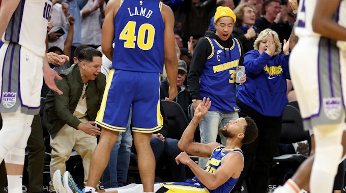 Stephen Curry von den Golden State Warriors feiert einen Dreier auf dem Hallenboden.