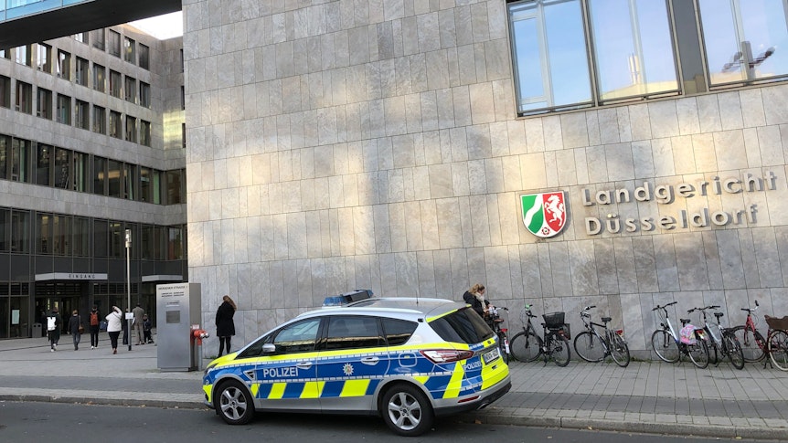Außenansicht des Landgerichts Düsseldorf. Davor steht ein Polizeiwagen.