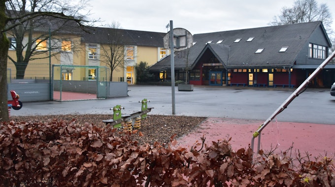 Der Schulhof der Janusz-Korczak-Grundschule in Much-Marienfeld ist leer, im Hintergrund sind die Schulgebäude zu sehen.