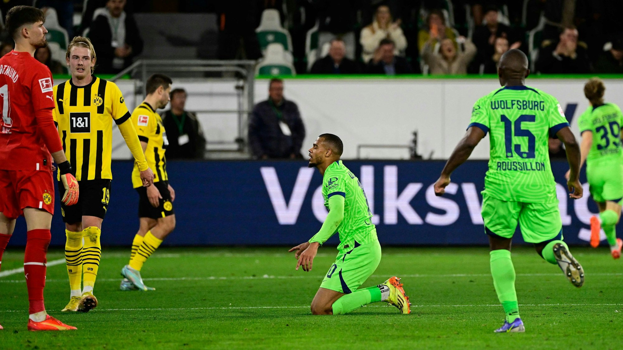 Lukas Nmecha kniet nach einem Tor für den VfL Wolfsburg auf dem Boden