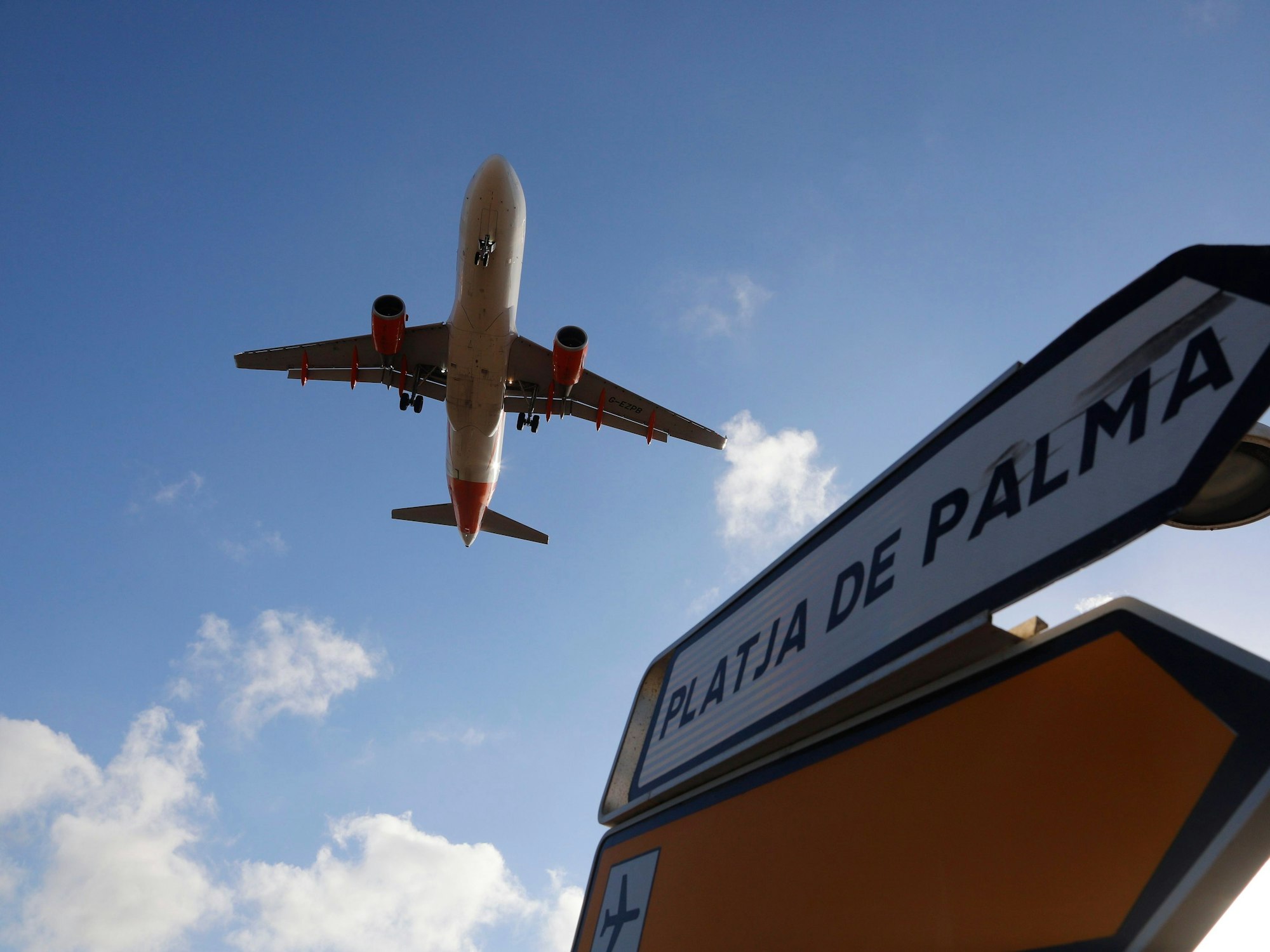 Ein Flugzeug überfliegt bei der Landung auf Mallorca am 18. August 2020 ein Schild, das die Richtung nach Playa de Palma anzeigt.