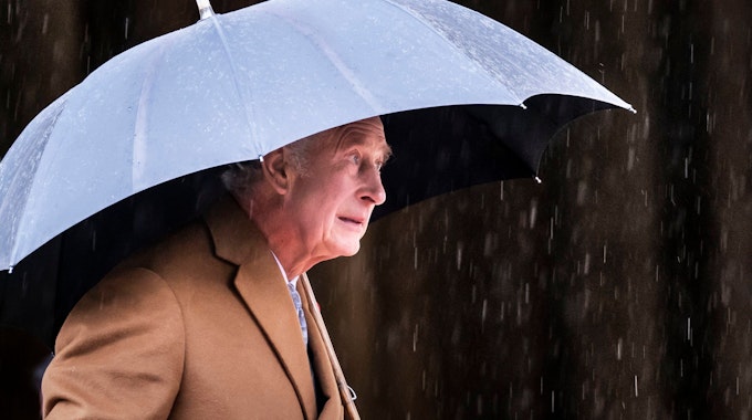 König Charles III. vor dem York Minster unter einem Regenschirm.