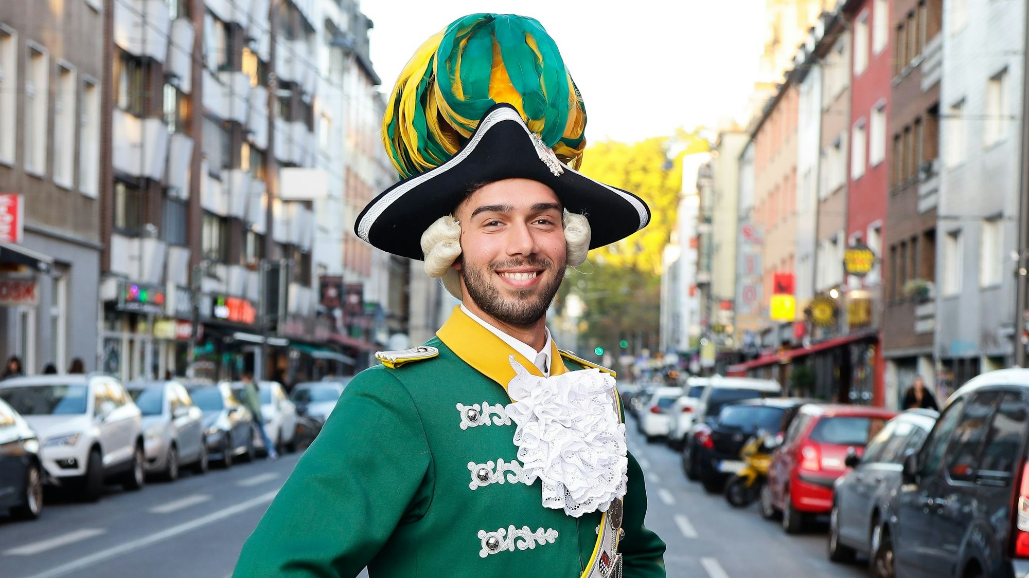 Davide Giangualano in der grün-gelben Unifor der Kölner Karnevalsgesellschaft "Ehrengarde" auf der Zülpicher Strasse.