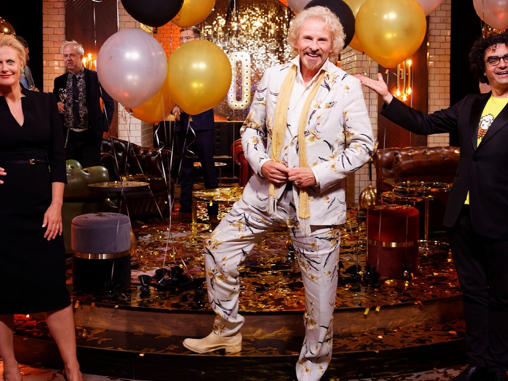 Von Kopf bis Fuß in Silber feierte Gottschalk live im ZDF in seinen 70. Geburtstag. Aber es wäre nicht das Outfit des Lockenkopfs, wenn es nicht über und über mit Blumenmustern bestickt wäre. Ein dünner, gelber Schal machte seinen Geburtstags-Aufzug komplett.