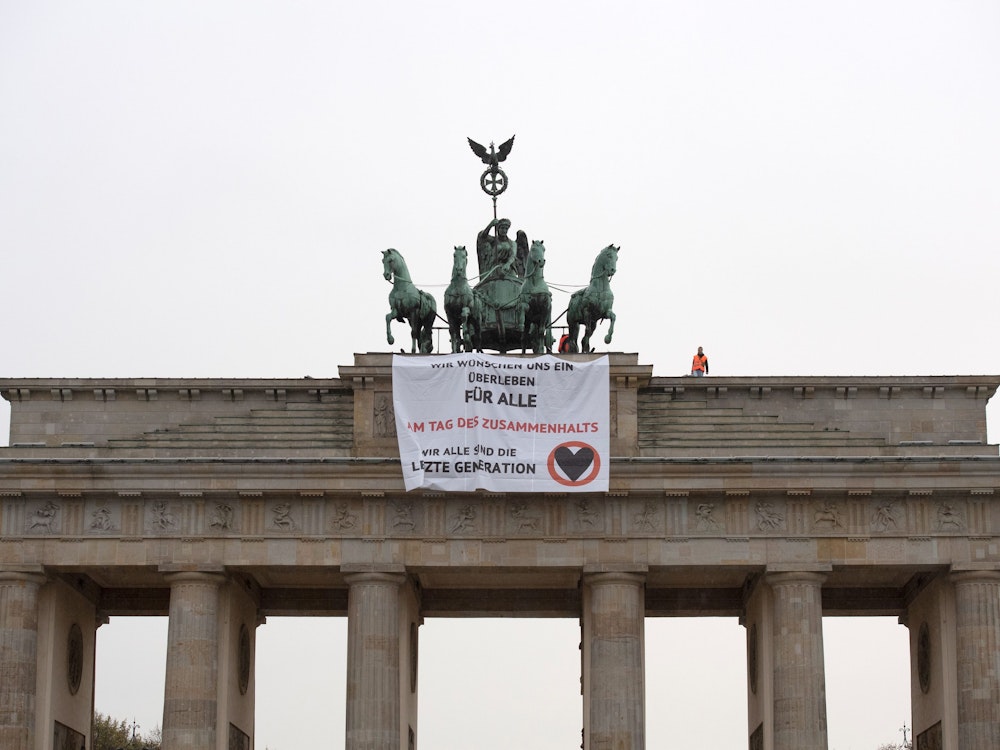 Aktivisten der Gruppe "Letzte Generation" haben das Brandenburger Tor in Berlin besetzt und ein Transparent aufgehangen.
