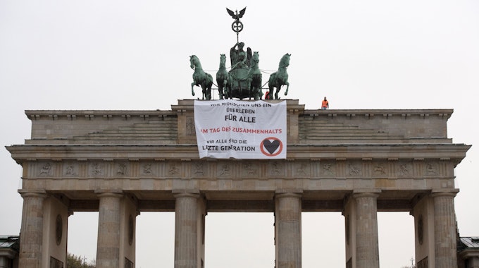 Aktivisten der Gruppe "Letzte Generation" haben das Brandenburger Tor in Berlin besetzt und ein Transparent aufgehangen.