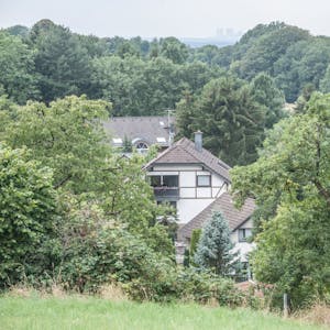 Dächer von Häusern hinter Bäumen im Burscheider Dorf Dürscheid, nahe der A 1.