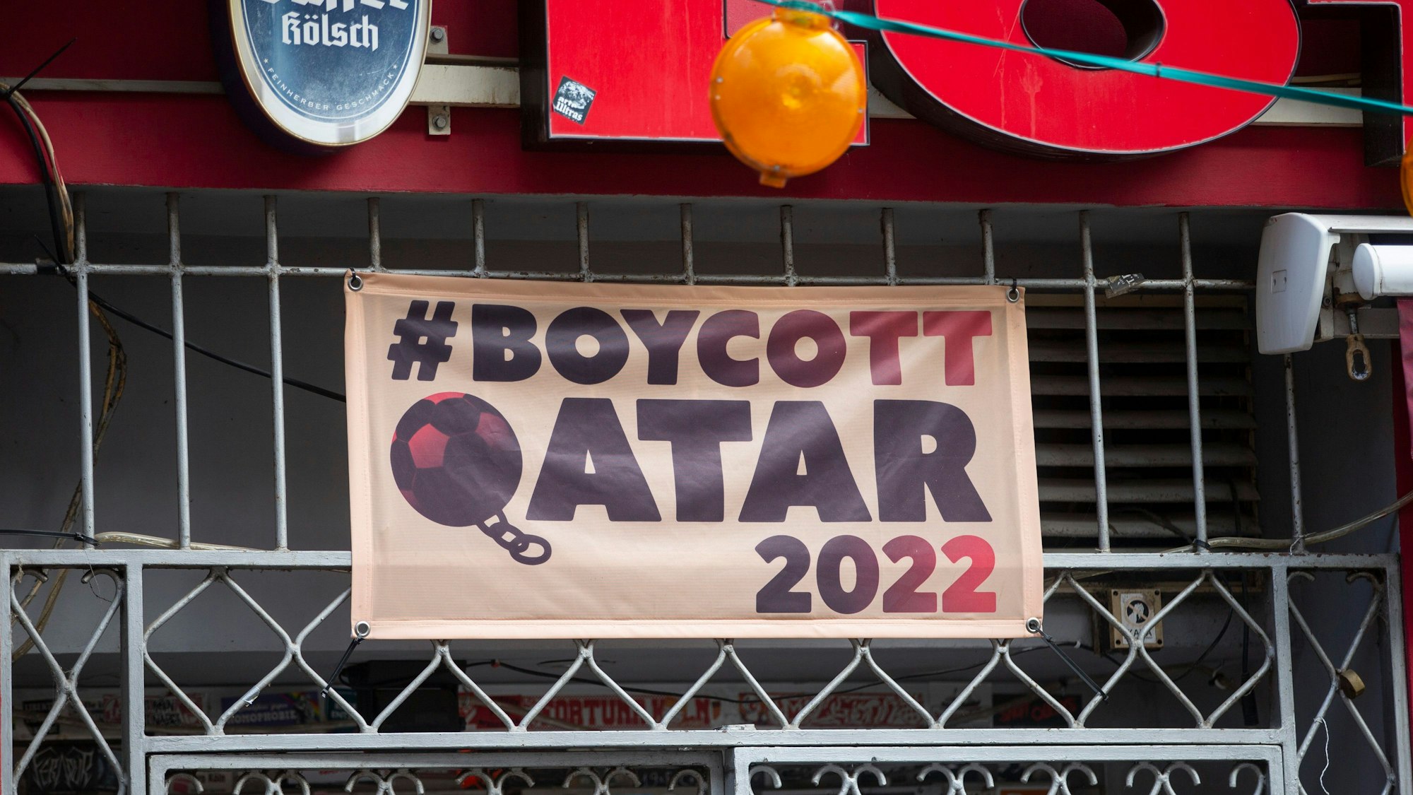 Ein Plakat mit dem Hashtag Boycott Qatar 2022 hängt vor der Kölner Kneipe Lotta.