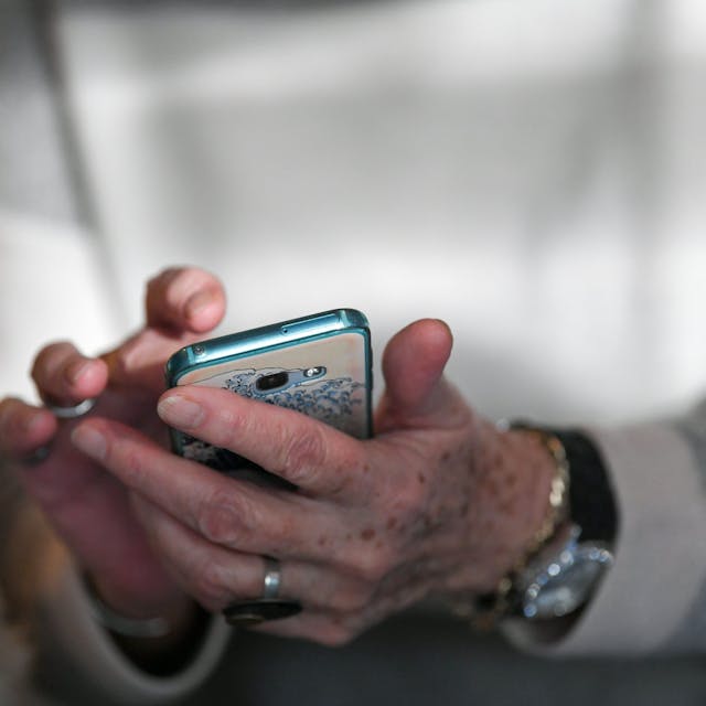 Eine Seniorin hält ihr Smartphone in den Händen.&nbsp;
