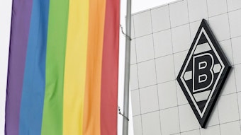 Die Regenbogenfahne im Borussia-Park, im Hintergrund ist das Vereinslogo von Fußball-Bundesligist Borussia Mönchengladbach auf dem Gebäude „8 Grad“ zu sehen.