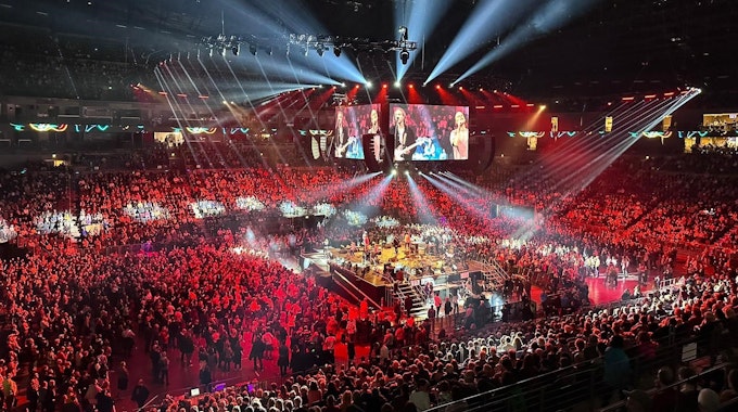 Blick auf den Innenraum in der Arena mit der Bühne in der Mitte, auf der die Band Cat Ballou steht.