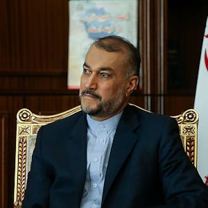 Hossein Amir-Abdollahian, iranischer Außenminister, sitzt auf einem goldenen Stuhl, im Hintergrund ist eine iranische Fahne zu sehen.