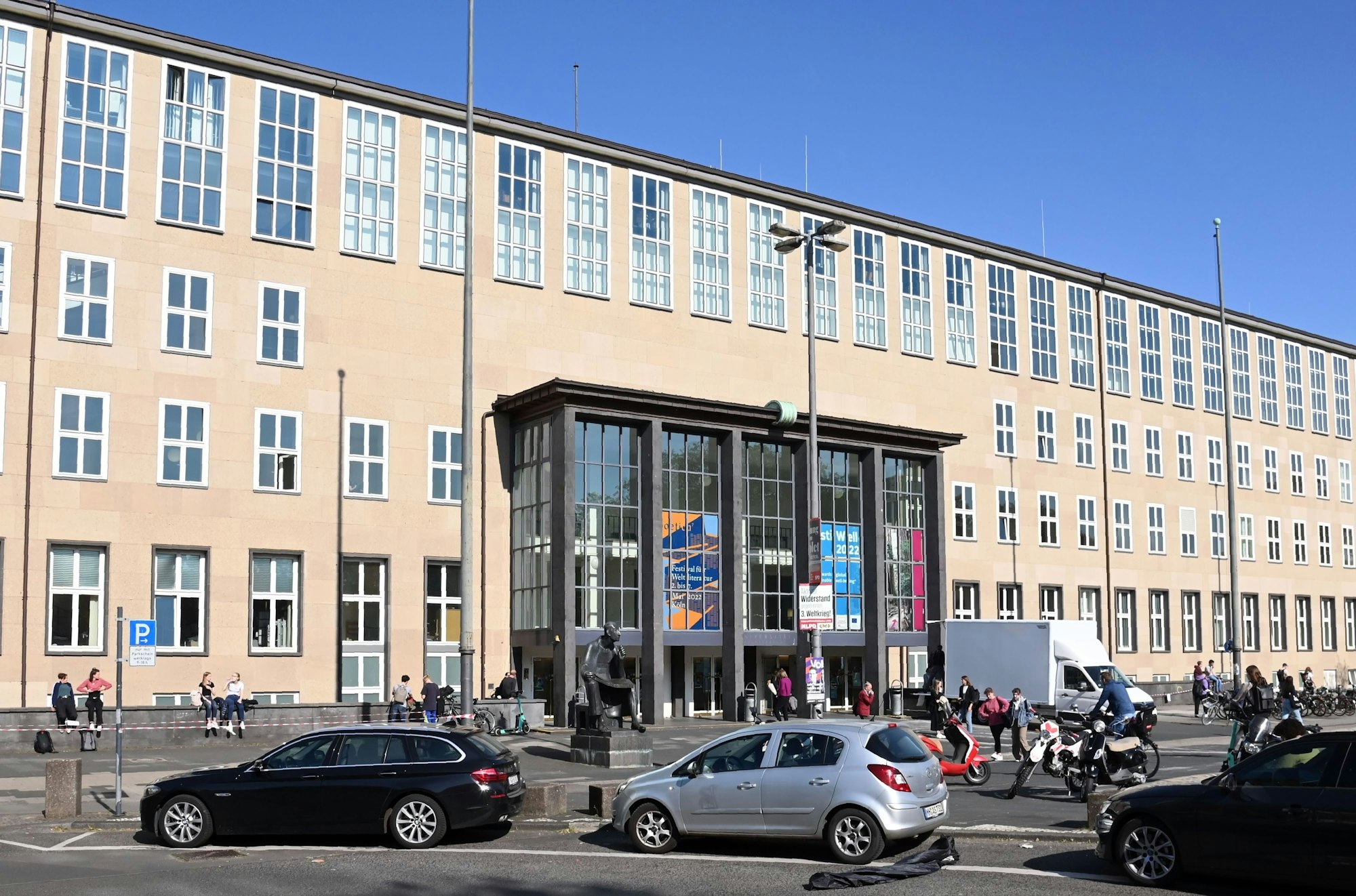 Das Hauptgebäude der Universität Köln am Albertus-Magnus-Platz vor einem blauen Himmel.