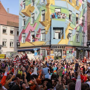 Die Zülpicher Straße, mit Blickrichtung auf die Kneipe "Der Stiefel" am 11.11. zum Karnevals-Sessionsauftakt. An der Kreuzung hat sich eine große Menge junger, verkleideter Menschen angesammelt.