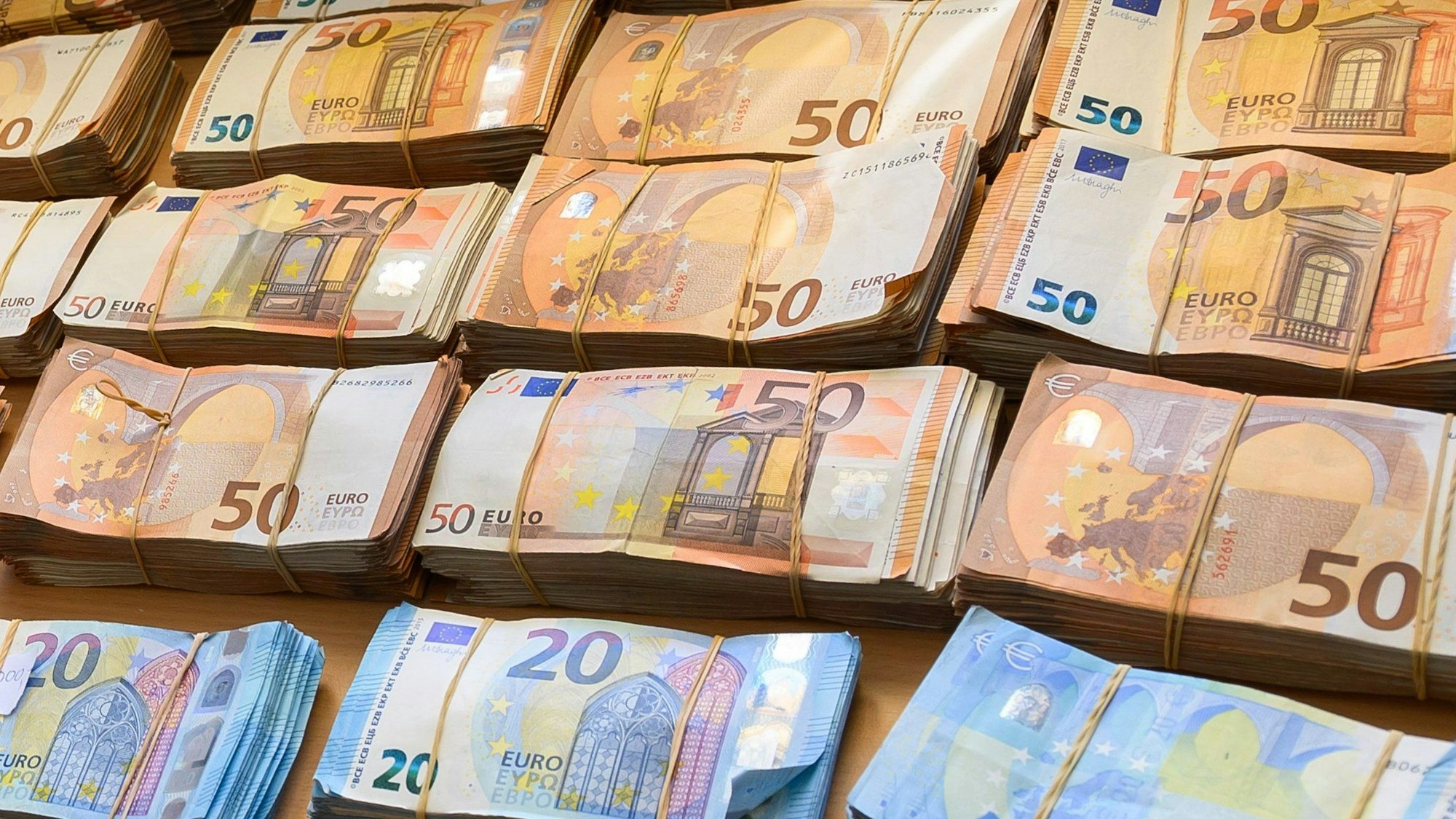 Bündel von Euro-Banknoten liegen auf einem Tisch.