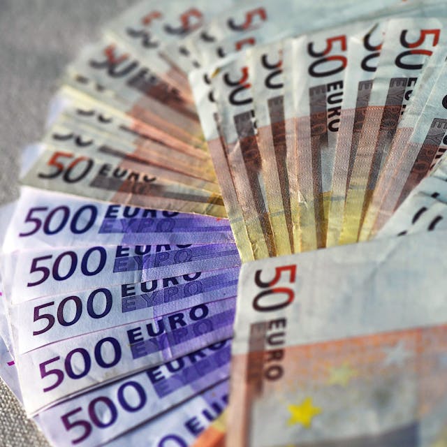 Viele Euro-Banknoten liegen ausgebreitet auf einem Tisch
