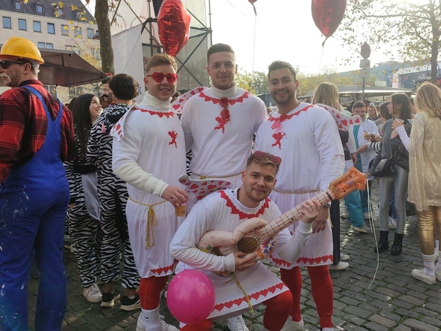 Vier Freunde aus Stuttgart mit Kostümen im Kölner Karneval unterwegs.