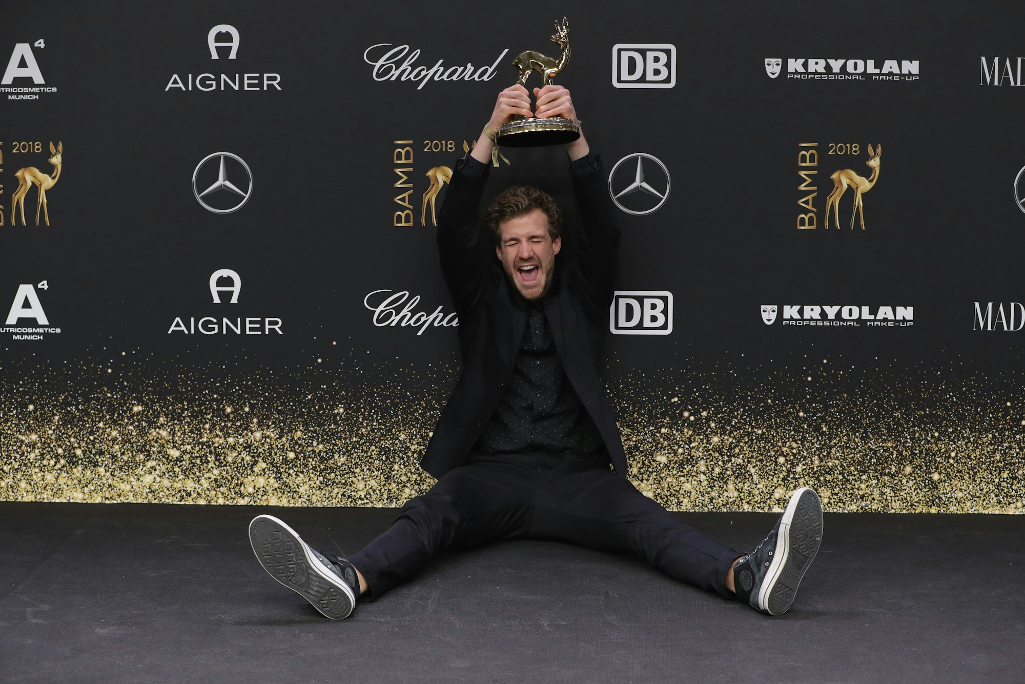 Luke Mockridge sitzt auf dem Teppich und freut sich über den Bambi in Berlin.