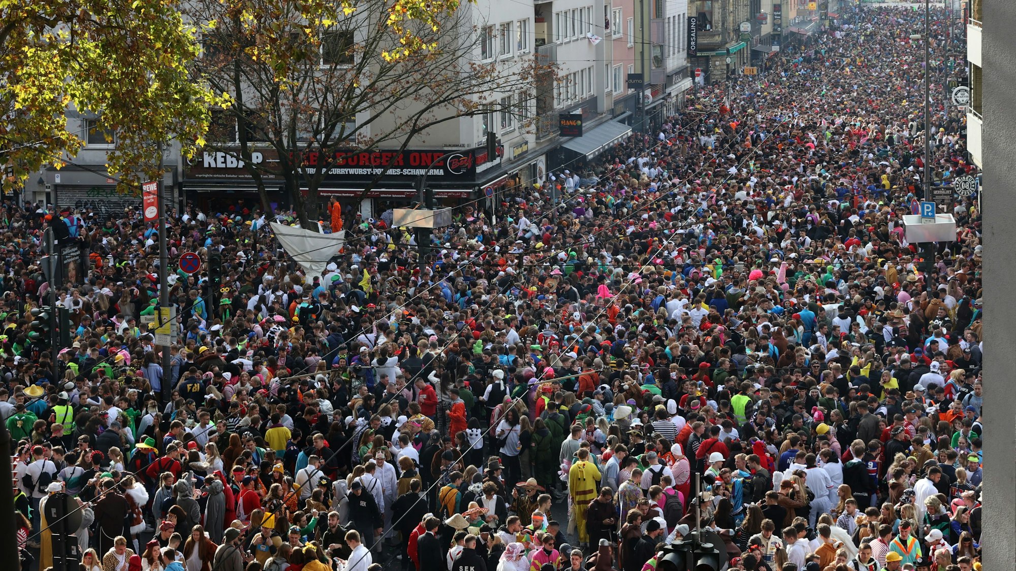 Dicht gedrängt stehen kostümierte Menschen am 11.11. auf der Zülpicher Straße zusammen.