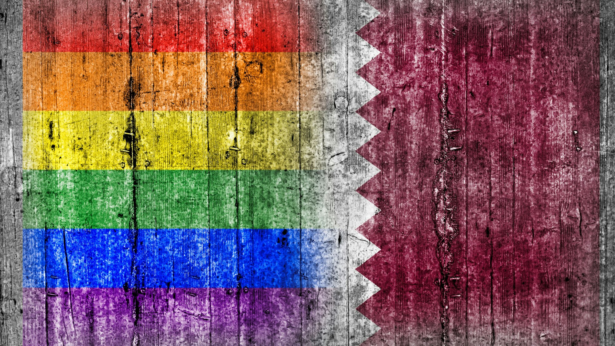 Die LGBT- und die Katar-Flagge sind nebeneinander auf eine Betonwand gemalt.