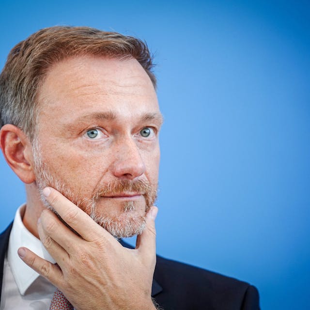 Bundesfinanzminister Christian Lindner in nachdenklicher Pose vor blauem Hintergrund.&nbsp;&nbsp;