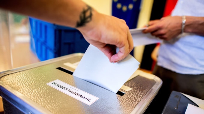 Ein Wähler wirft in einem Wahllokal, das im Klassenraum einer Grundschule im Stadtteil Prenzlauer Berg untergebracht ist, seinen Stimmzettel für die Bundestagswahl in eine Wahlurne.&nbsp;
