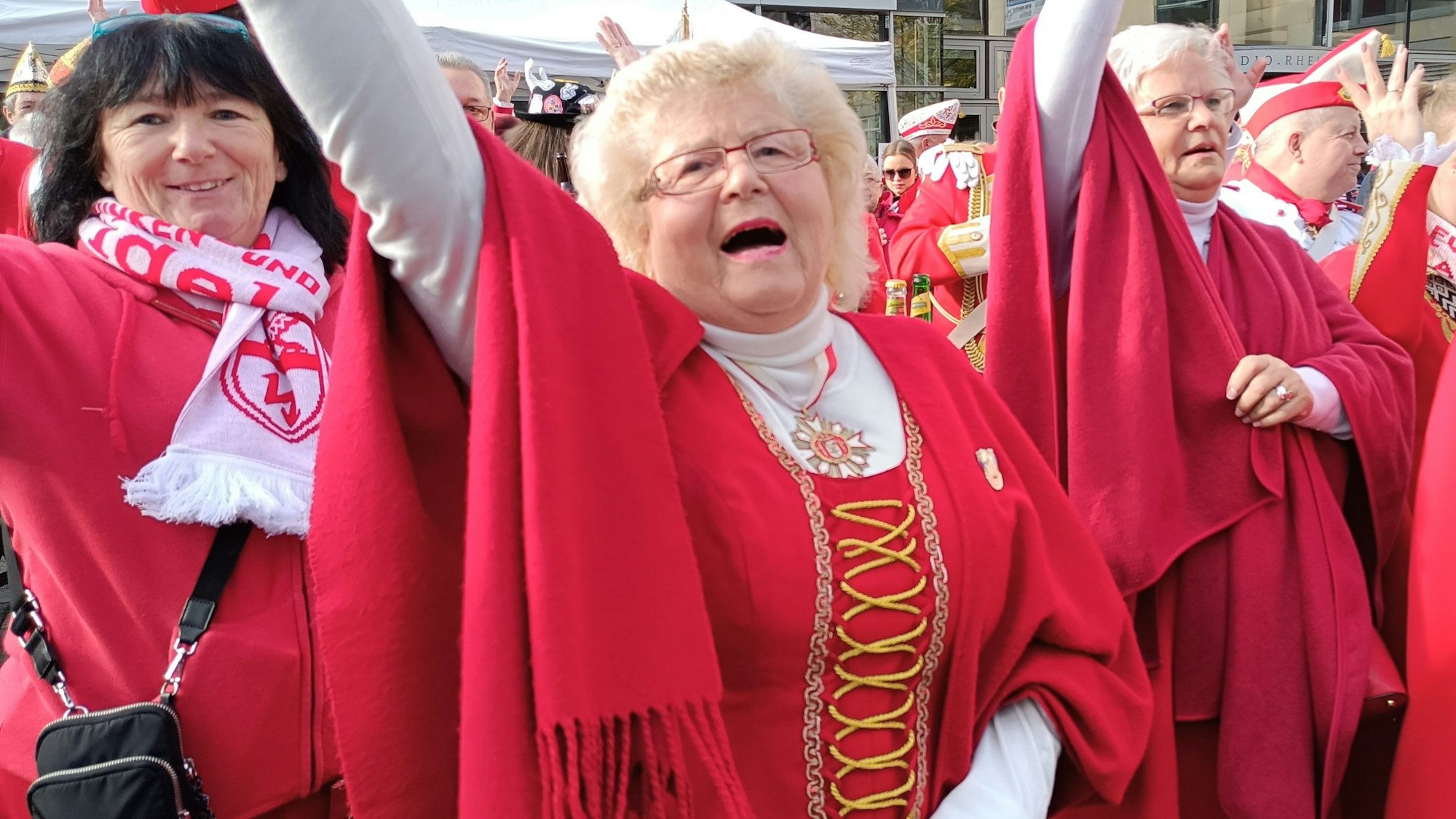 Karnevalistinnen jubeln und feiern in roter Kleidung den Sessionsauftakt in Bergheim.