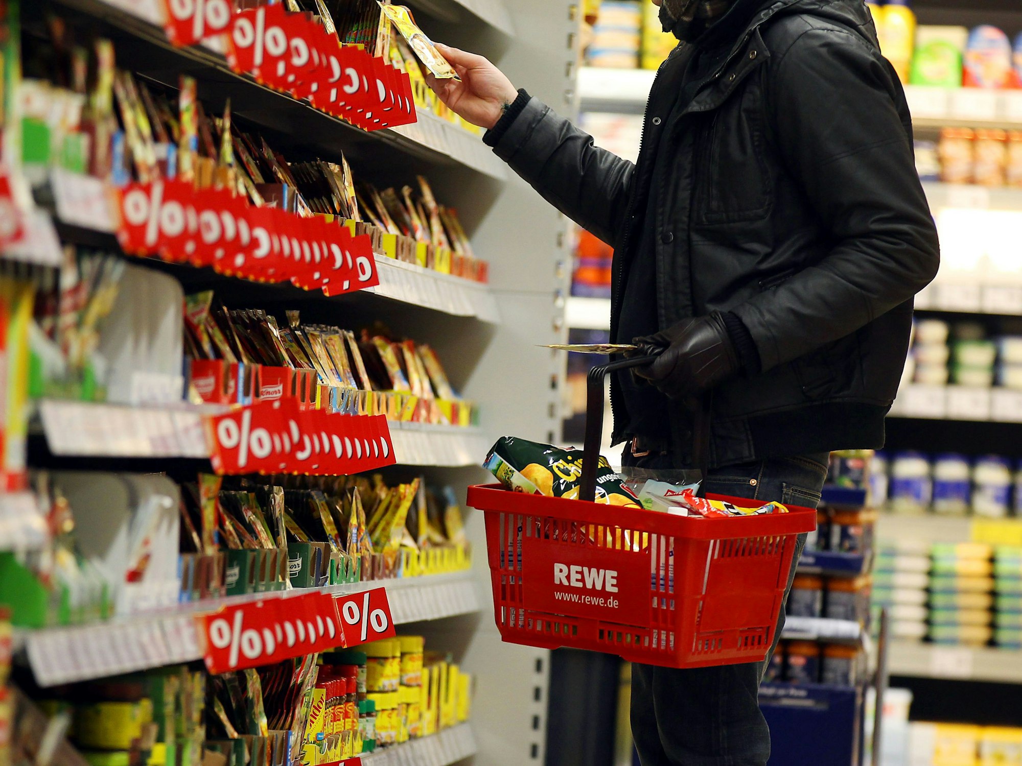 Ein Kunde steht in Köln in einem Rewe-Supermarkt an einem Regal (Symbolfoto).