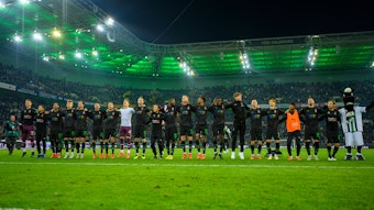 Die Profis von Fußball-Bundesligist Borussia Mönchengladbach feiern am Freitag (11. November 2022) gemeinsam mit den den Fans im Borussia-Park den 4:2-Sieg gegen Borussia Dortmund. Die Spieler umarmen sich und hüpfen gemeinsam. Auch Maskottchen Jünter ist dabei.