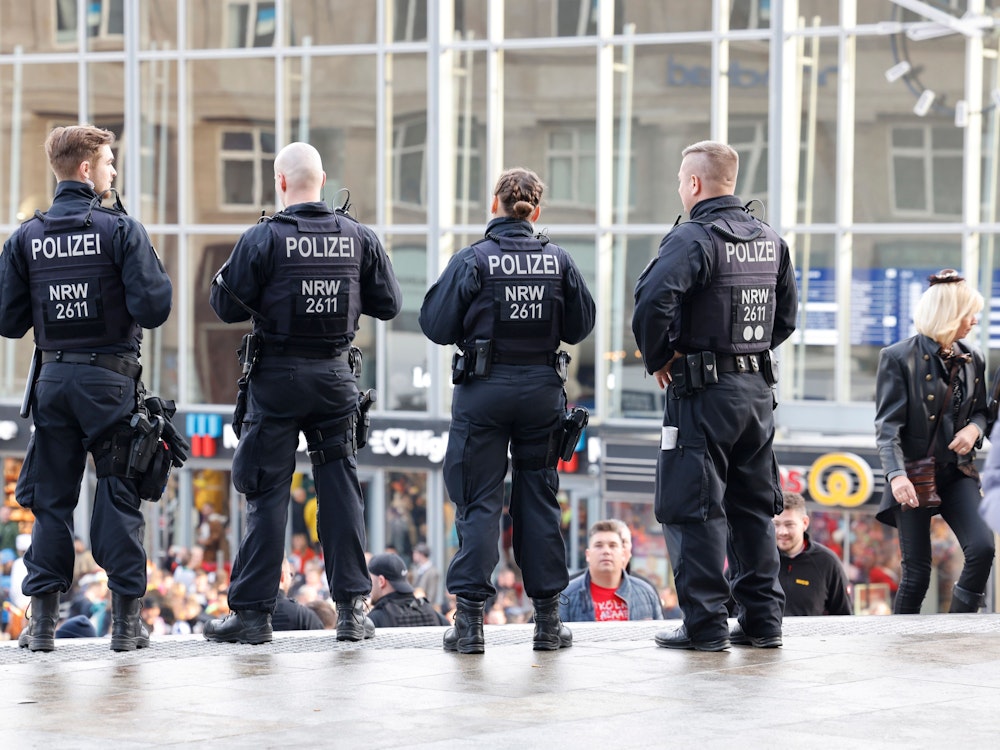 Vier Polizeibeamte stehen vor dem Kölner Hauptbahnhof.
