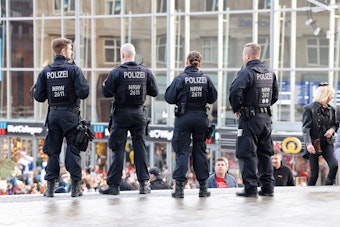 Vier Polizeibeamte stehen vor dem Kölner Hauptbahnhof.