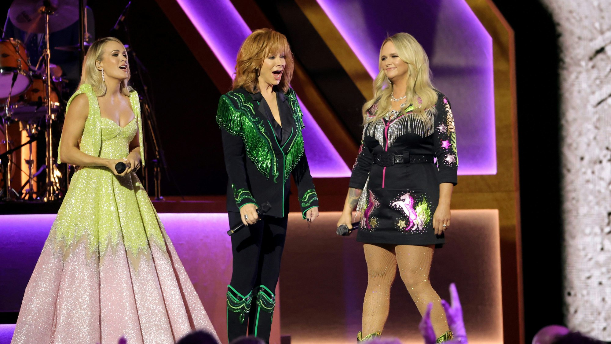 Carrie Underwood, Reba McEntire und Miranda Lambert auf der Bühne. Sie tragen aufwändige Bühnengarderobe.