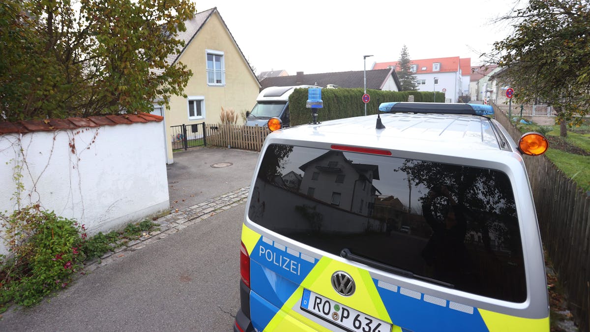 Ein Polizeiauto steht vor dem Haus in Weilheim, in dem es zu der Bluttat mit vier Toten gekommen ist.