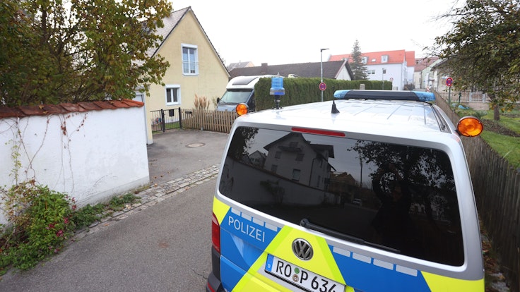 Ein Polizeiauto steht vor dem Haus in Weilheim, in dem es zu der Bluttat mit vier Toten gekommen ist.