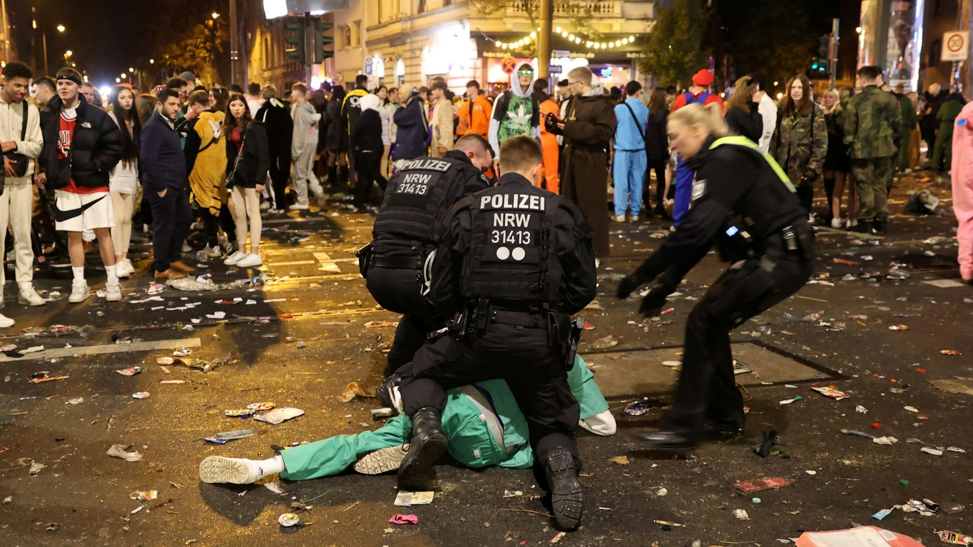Polizisten bringen am 11.11. 2022 auf der Zülpicher Straße einen als Arzt kostümierten jungen Mann zu Boden.