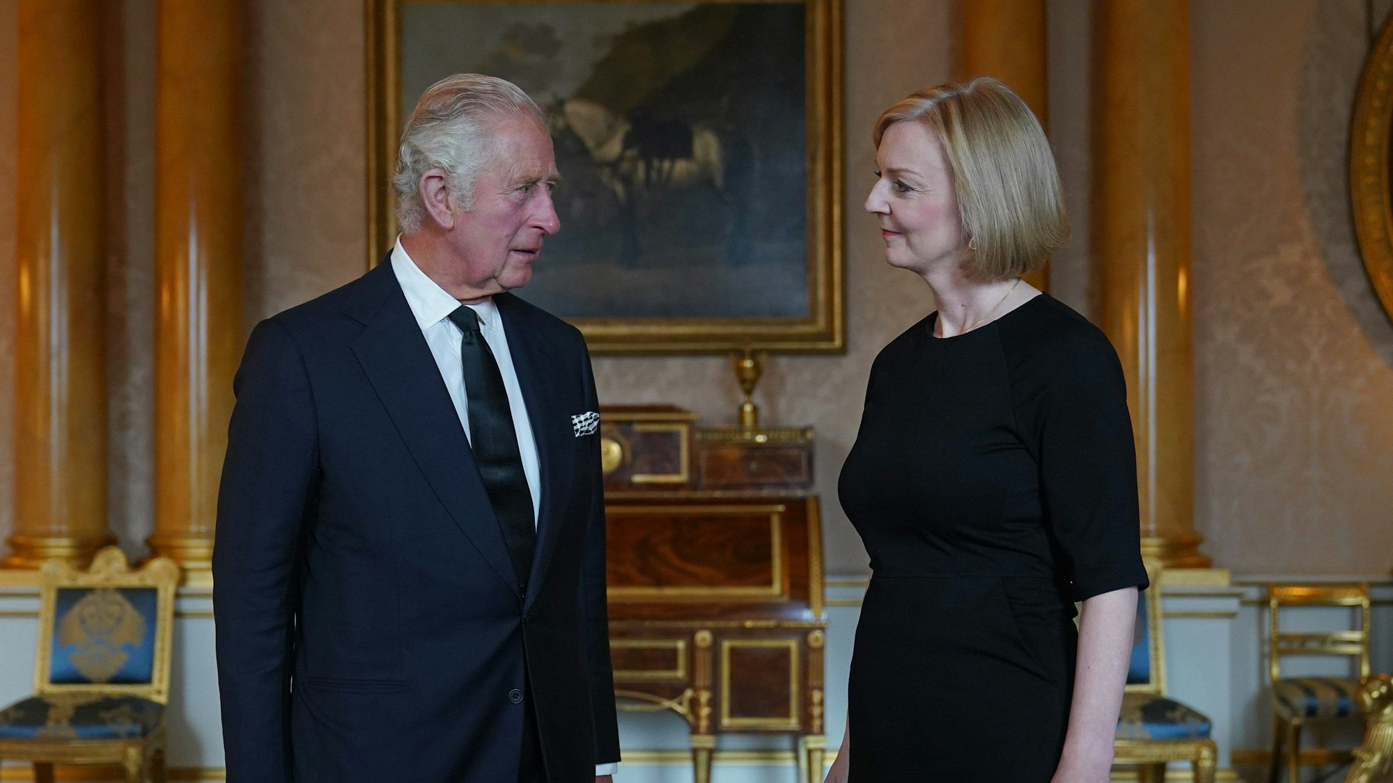 König Charles III. von Großbritannien empfängt die ehemalige Premierministerin Liz Truss zu deren ersten Audienz im Buckingham Palast nach dem Tod der Queen. Sie stehen sich gegenüber und schauen sich an.