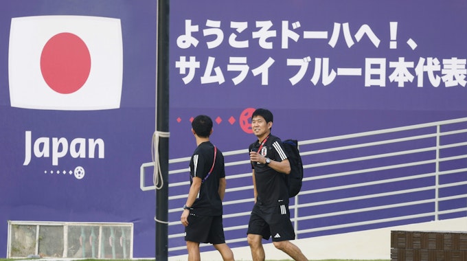Japans Fußballtrainer Hajime Moriyasu (r.) prüft den Zustand des Spielfelds in der Trainingsanlage des Al Sadd Sports Club in Doha, die der Nationalmannschaft aus Japan während der Weltmeisterschaft als Basislager dienen wird.