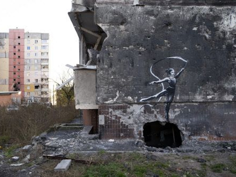 Sonntag, 13. November: Auf der grauen Wand des Gebäudes ist eine Person zu sehen, die über einem Loch als Ballerina tanzt.