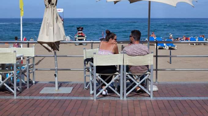 Urlauber sitzen am 14.10.2020 im Außenbereich einer Bar am Strand Las Canteras in Gran Canaria.